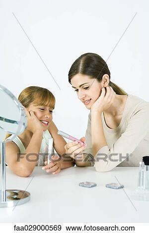 Young woman and preteen sister looking at cosmetics together, both smiling View Large Photo Image Stock Photo - Young woman and preteen sister looking at cosmetics together, both smiling. Fotosearch