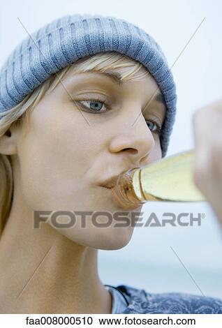 Young woman drinking from bottle of beer, close-up View Large Photo Image Stock Image - Young woman drinking from bottle of beer, close-up. Fotosearch