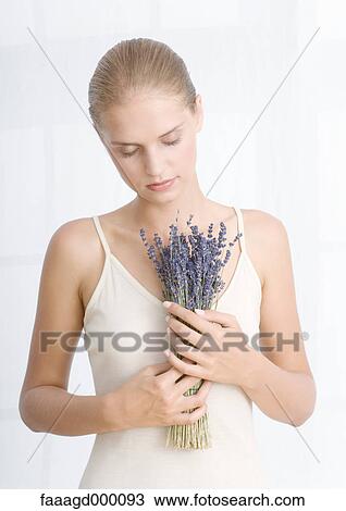 Stock Image - Young woman holding bouquet of lavendar. Fotosearch