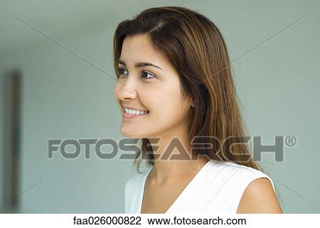 Young woman smiling, looking out of frame, head and shoulders, portrait View Large Photo Image Stock Image - Young woman smiling, looking out of frame, head and shoulders, portrait. Fotosearch