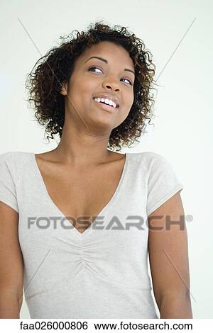Young woman smiling, looking to the side, waist up View Large Photo Image Stock Photograph - Young woman smiling, looking to the side, waist up. Fotosearch