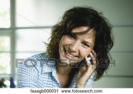 Stock Image - Young woman using cell phone. Fotosearch