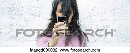 Stock Image - Young woman using photophone. Fotosearch