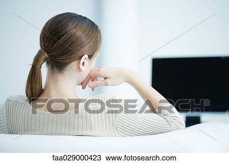Young woman watching TV, rear view View Large Photo Image Stock Image - Young woman watching TV, rear view. Fotosearch