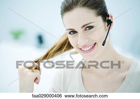 Young woman wearing headset, smiling at camera View Large Photo Image Stock Photograph - Young woman wearing headset, smiling at camera. Fotosearch