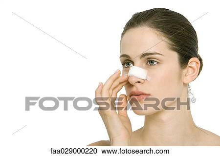 Young woman with bandage on nose, looking away View Large Photo Image Stock Image - Young woman with bandage on nose, looking away. Fotosearch
