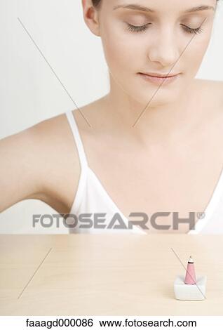 Young woman with cone of incense burning View Large Photo Image Stock Photograph - Young woman with cone of incense burning. Fotosearch