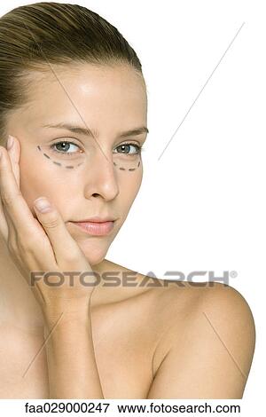 Young woman with plastic surgery markings under eyes, touching cheek, looking at camera View Large Photo Image Stock Photo - Young woman with plastic surgery markings under eyes, touching cheek, looking at camera. Fotosearch