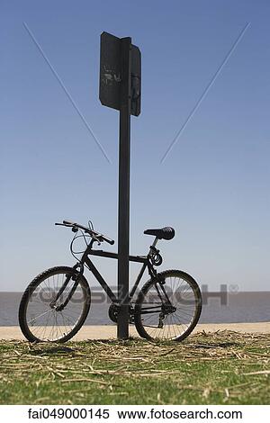Bicycle leaning against street sign, beach in background View Large Photo Image Stock Photography - Bicycle leaning against street sign, beach in background. Fotosearch