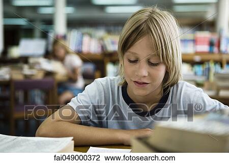 Boy reading in library View Large Photo Image Stock Image - Boy reading in library. Fotosearch