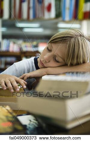 Boy resting head on arms asleep in library View Large Photo Image Stock Image - Boy resting head on arms asleep in library. Fotosearch