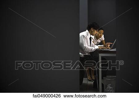 Business associates together in office working late View Large Photo Image Stock Photograph - Business associates together in office working late. Fotosearch