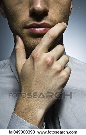 Businessman with hand under chin, portrait View Large Photo Image Stock Image - Businessman with hand under chin, portrait. Fotosearch