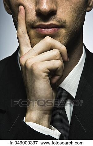 Businessman with hand under chin, portrait View Large Photo Image Stock Photo - Businessman with hand under chin, portrait. Fotosearch