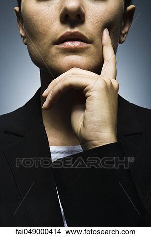 Businesswoman with hand held under chin deep in thought, portrait View Large Photo Image Picture - Businesswoman with hand held under chin deep in thought, portrait. Fotosearch