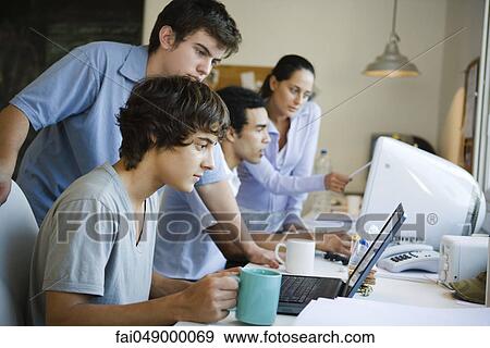 College students collaborating together using computers View Large Photo Image Stock Photo - College students collaborating together using computers. Fotosearch