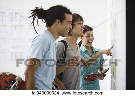 College students looking with pleased expressions at results posted on bulletin board View Large Photo Image Picture - College students looking with pleased expressions at results posted on bulletin board. Fotosearch