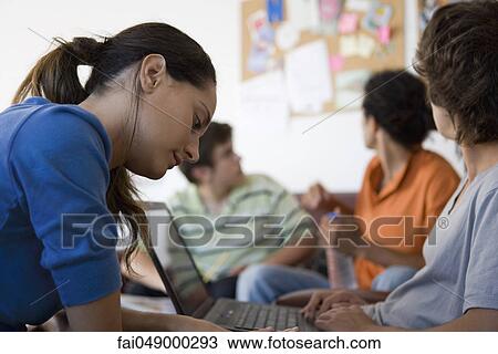 College students sitting in break room, woman in foreground looking down at hand View Large Photo Image Stock Image - College students sitting in break room, woman in foreground looking down at hand. Fotosearch