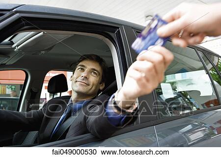 Customer in drive-thru handing credit card to check-out window clerk View Large Photo Image Stock Image - Customer in drive-thru handing credit card to check-out window clerk. Fotosearch