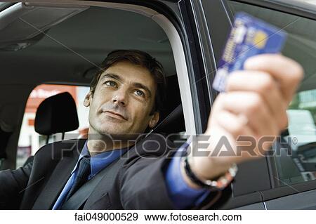 Customer in drive-thru handing credit card to check-out window clerk View Large Photo Image Stock Photo - Customer in drive-thru handing credit card to check-out window clerk. Fotosearch