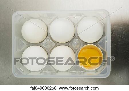 Eggs in egg carton, one cracked open View Large Photo Image Stock Photo - Eggs in egg carton, one cracked open. Fotosearch