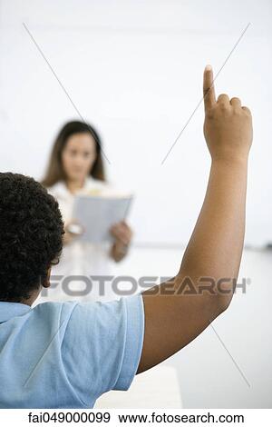 Elementary school student raising hand in class, rear view View Large Photo Image Stock Photo - Elementary school student raising hand in class, rear view. Fotosearch