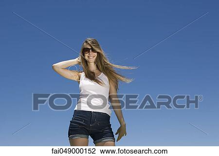 Fashionable young woman in summer apparel with hand in hair View Large Photo Image Stock Image - Fashionable young woman in summer apparel with hand in hair. Fotosearch