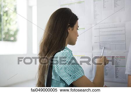 Female college student checking bulletin board View Large Photo Image Stock Photography - Female college student checking bulletin board. Fotosearch