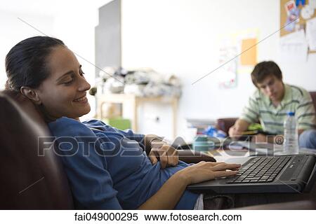 Female college student relaxing in break room, using laptop computer View Large Photo Image Stock Photography - Female college student relaxing in break room, using laptop computer. Fotosearch