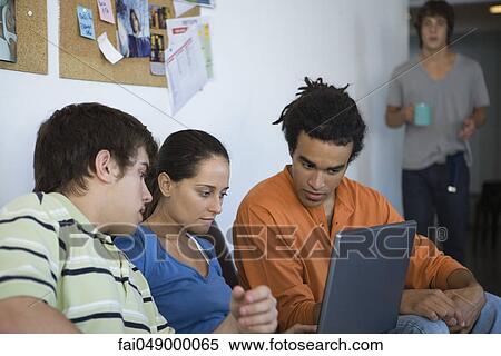 Female college student using laptop computer, friends sitting on either side watching View Large Photo Image Stock Photography - Female college student using laptop computer, friends sitting on either side watching. Fotosearch