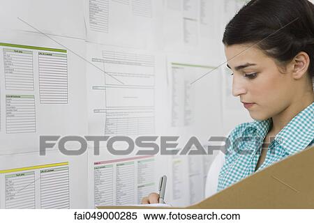 Female college student writing down information posted on bulletin board View Large Photo Image Stock Photography - Female college student writing down information posted on bulletin board. Fotosearch