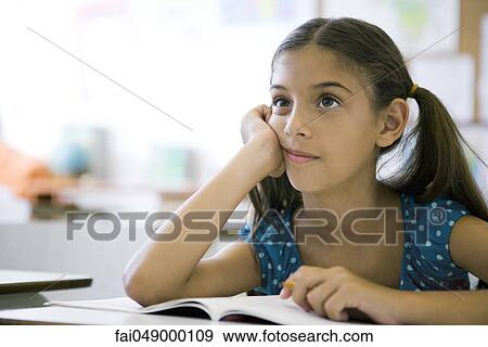 Stock Photo - Female elementary school student daydreaming in class. Fotosearch