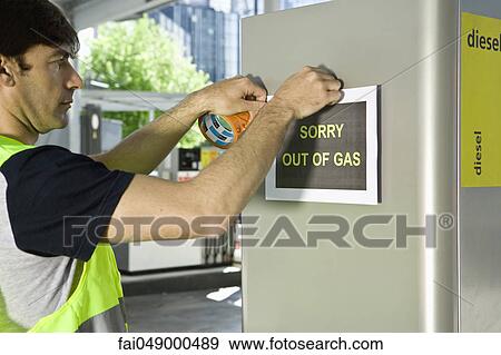 Gas station attendant posting sign at gas pump reading "Sorry out of gas" View Large Photo Image Stock Photo - Gas station attendant posting sign at gas pump reading "Sorry out of gas". Fotosearch
