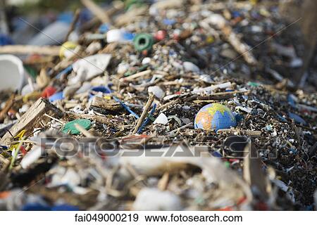 Globe in midst of landfill trash View Large Photo Image Stock Photo - Globe in midst of landfill trash. Fotosearch
