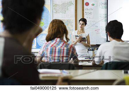 Stock Photography - High school student reading book aloud to class. Fotosearch