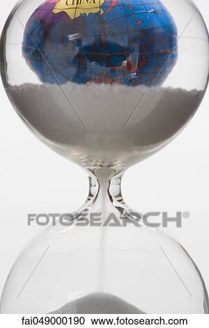 Hourglass, globe in background View Large Photo Image Stock Image - Hourglass, globe in background. Fotosearch