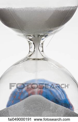 Stock Image - Hourglass, globe in background. Fotosearch