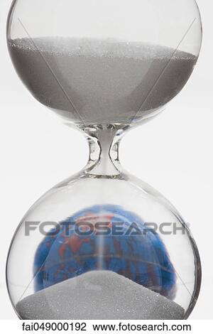 Hourglass, globe in background View Large Photo Image Stock Image - Hourglass, globe in background. Fotosearch
