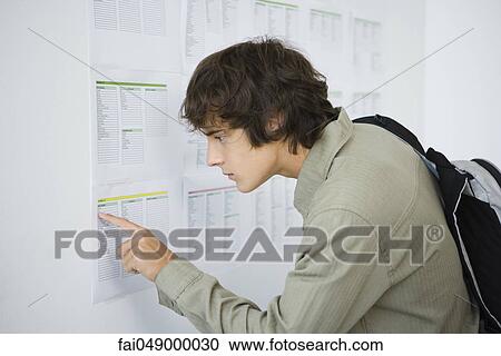 Male college student checking results posted on bulletin board View Large Photo Image Stock Image - Male college student checking results posted on bulletin board. Fotosearch