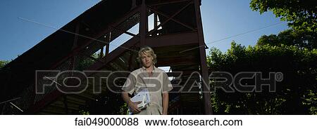 Male college student standing outdoors, looking at camera, portrait View Large Photo Image Stock Photo - Male college student standing outdoors, looking at camera, portrait. Fotosearch