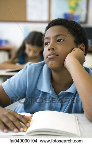 Male elementary school student daydreaming in class View Large Photo Image Picture - Male elementary school student daydreaming in class. Fotosearch