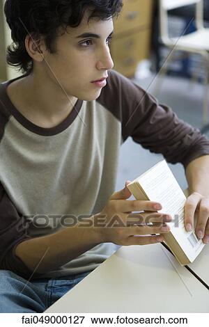 Male high school student in class, holding book View Large Photo Image Stock Photo - Male high school student in class, holding book. Fotosearch