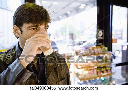 Man drinking coffee in convenience store View Large Photo Image Stock Photography - Man drinking coffee in convenience store. Fotosearch