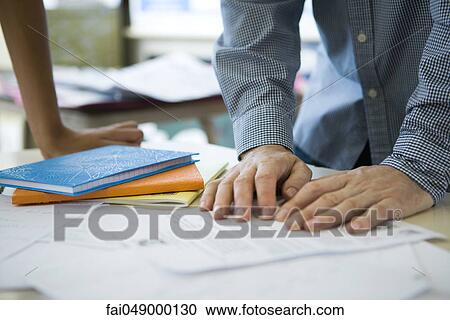 Man leaning over table reading document, cropped View Large Photo Image Stock Image - Man leaning over table reading document, cropped. Fotosearch