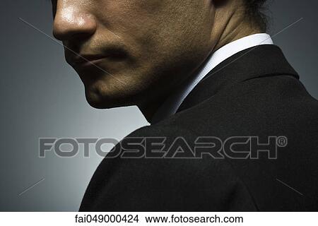 Picture - Man looking over shoulder with suspicion. Fotosearch