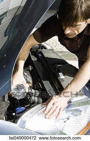 Man pouring water in radiator of overheated car View Large Photo Image Stock Image - Man pouring water in radiator of overheated car. Fotosearch