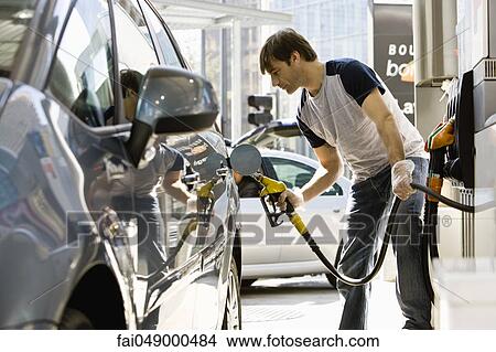 Man refueling vehicle at gas station View Large Photo Image Picture - Man refueling vehicle at gas station. Fotosearch