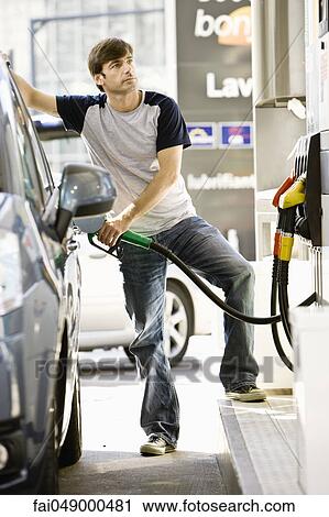 Stock Image - Man refueling vehicle at gas station. Fotosearch
