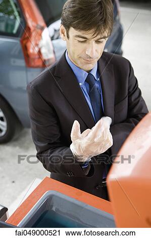Man taking off disposable gloves after refueling vehicle View Large Photo Image Stock Image - Man taking off disposable gloves after refueling vehicle. Fotosearch