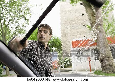 Man washing car windshield with squeegee View Large Photo Image Stock Photo - Man washing car windshield with squeegee. Fotosearch